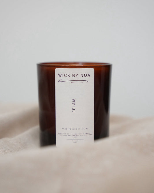 Candle with a label on a beige surface