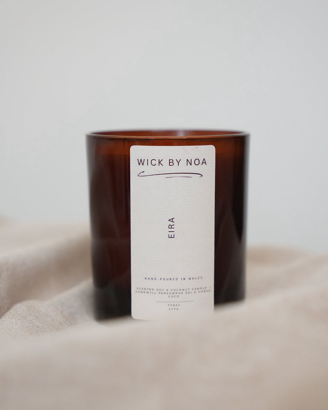 Candle with a label on a beige surface